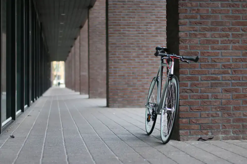 A sleek hybrid commuter bike parked against a brick wall